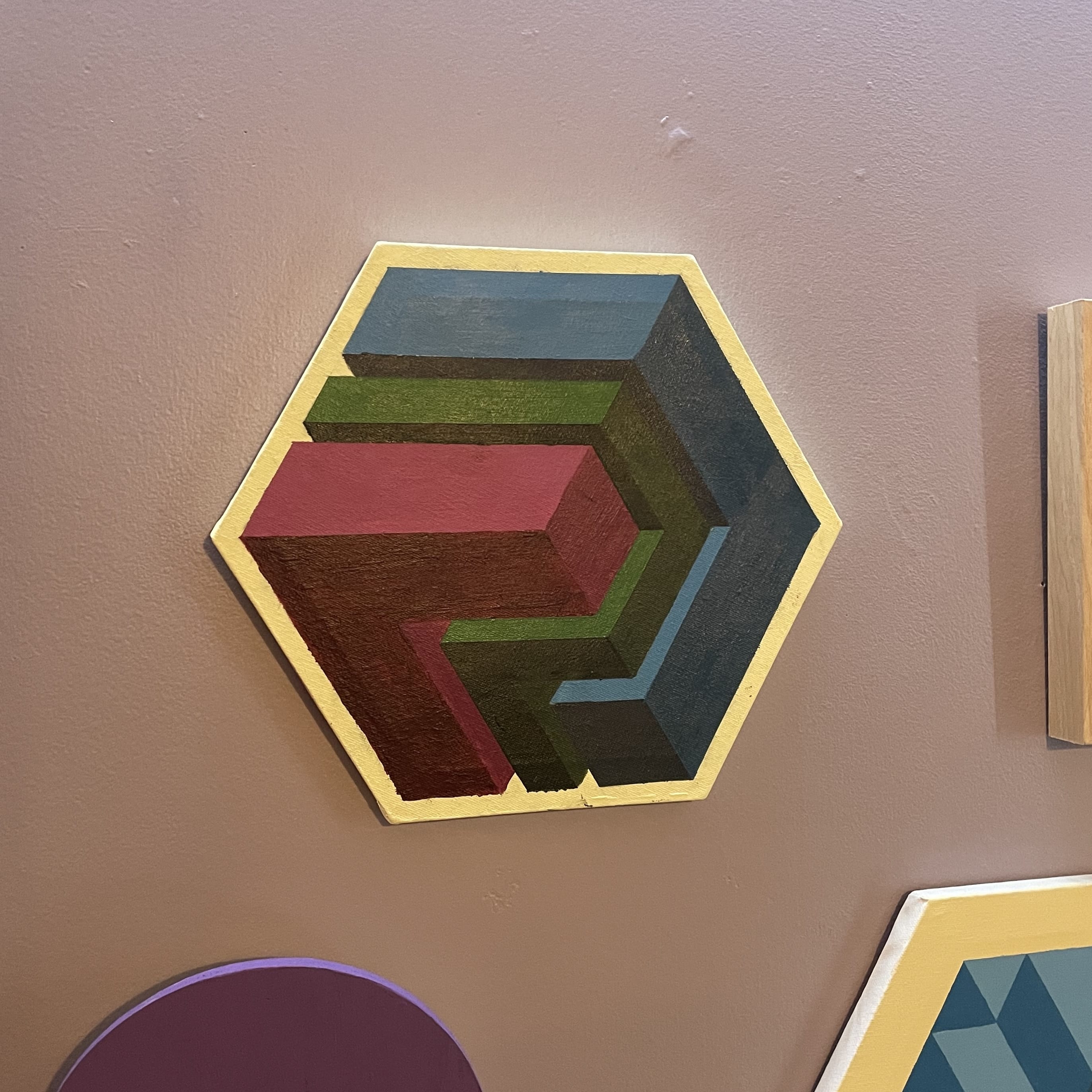 Colorful geometric shapes on a wall, including "L" shapes in blue, green and magenta.